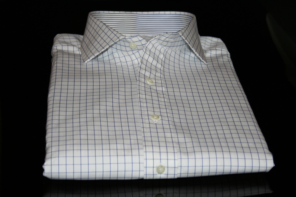 Another beautiful custom made shirt by Proper Cloth.  This design uses an Italian 80s pinpoint oxford cloth blue and white windowpane fabric.  Additionally, this customer designed shirt has a blue and white pencil stripe oxford cloth on the inside of the English spread collar and barrel cuffs.