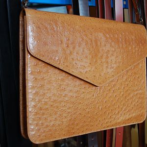 A 'mock' ostrich folio, suede lined with shoulder strap, machine stitched.